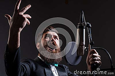 Singer singing rock. Sound producer recording song in a music studio. Excited Karaoke. Stock Photo