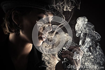 Singer woman with retro microphone in smoke Stock Photo