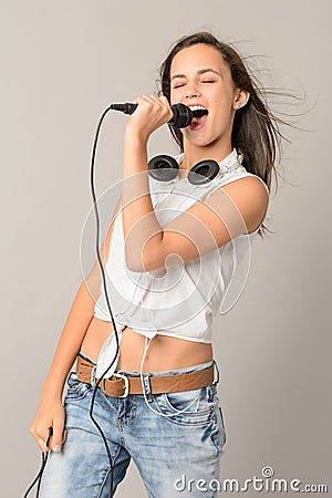 Singing teenage girl with microphone closed eyes Stock Photo