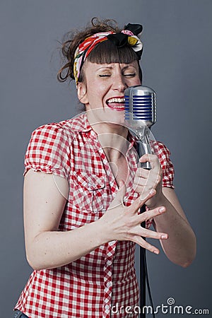 Singing young woman performing with retro micro Stock Photo