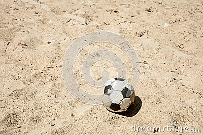 Single Ball on the beach with nobody. Broken classic ball on the sand. Stock Photo