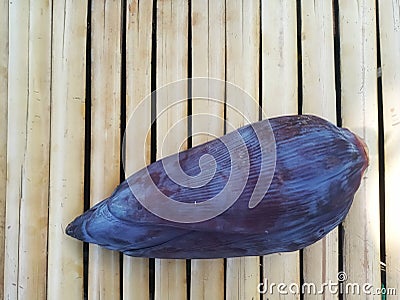 Single Banana Flower or Blossom on Bamboo Surface Stock Photo