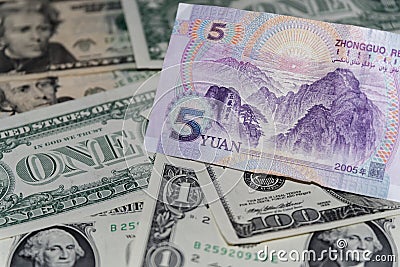 Banknote of five Chinese yuan against background of american dollars Stock Photo