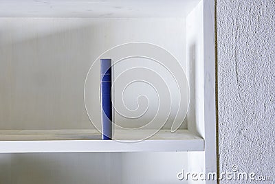 Single book standing upright in white shelf in white wall Stock Photo