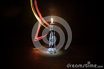 Single burning candle. Light of flame and flowing candle wax, dark background Stock Photo