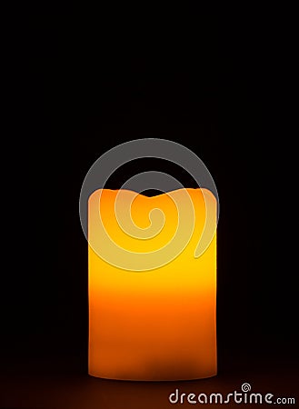 Single burning candle with warm orange red halo Stock Photo