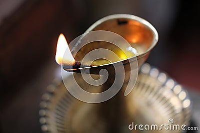 Single burning flame in a brass oil lamp Stock Photo