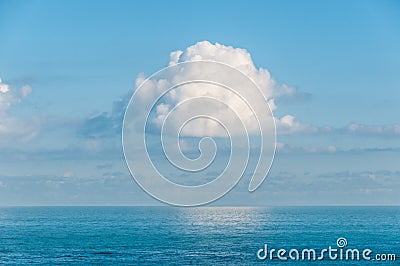 Single cloud suspended in the sky over the ocean. Stock Photo