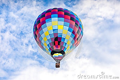 Single, colorful hot-air balloon high in the sky Stock Photo