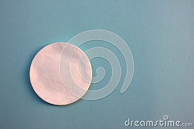 Single Cotton pad for skincare on blue background with copy space. Stock Photo