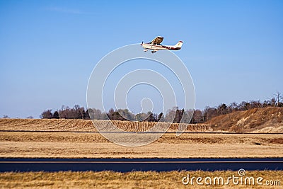Single Engine Propeller Plane Flying Over Runway in Autumn Editorial Stock Photo