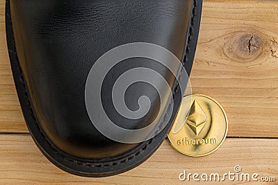 Single Ethereum cryptocurrency coin under a shoe Editorial Stock Photo