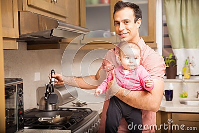 Single father cooking breakfast with a baby Stock Photo