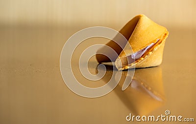 Single Fortune Cookie Reflects In Glossy Table Top Stock Photo
