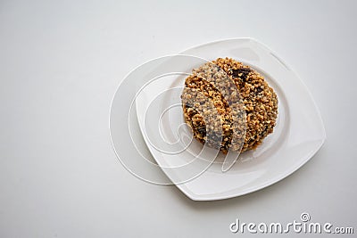 Single ground peanut coated on chocolate flour donut on white pl Stock Photo