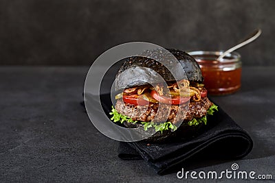 Single hamburger with black bread buns Stock Photo