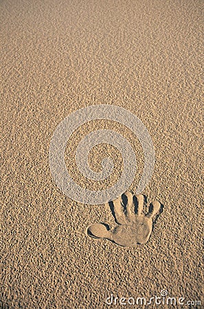 Single hand print in beige sand Stock Photo