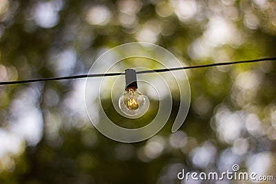 A single hanging lightbulb outside, exterior decoration Stock Photo