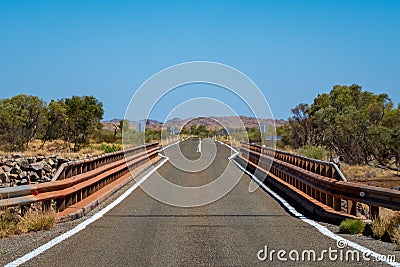 Single lane bridge interrupting two lane highway in Australian Outback Stock Photo