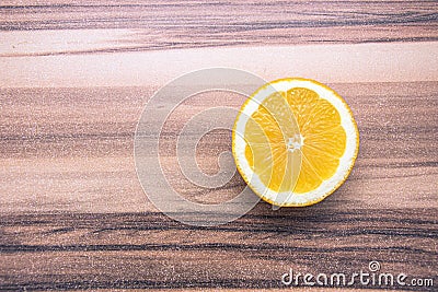 Single lemon piece turned upward on a wooden table Stock Photo