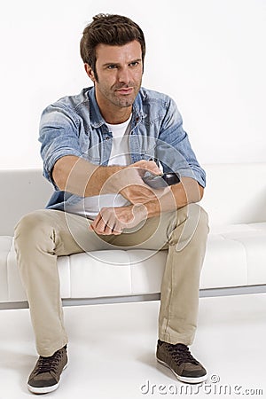 Single man on the couch watching TV Stock Photo