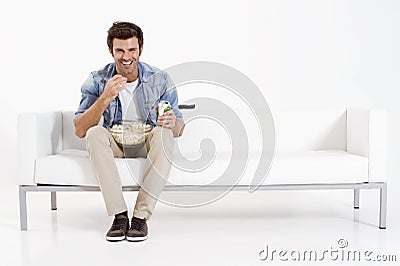 Single man on the couch watching TV Stock Photo