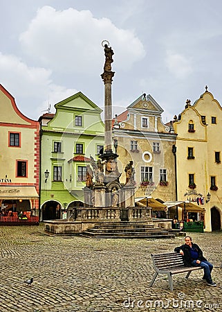 Single man sits on a bench in the center of Cesky Krumlov Editorial Stock Photo