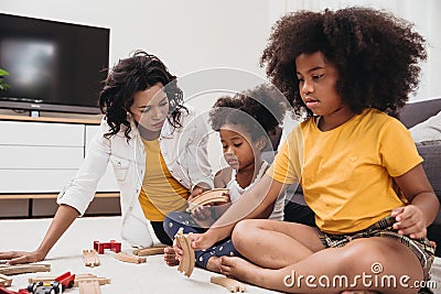 Single mom with two daughter playing toy in apartment. Nanny looking or childcare at home black people Stock Photo