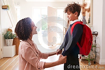 Single Mother At Home Getting Son Wearing Uniform Ready For First Day Of School Stock Photo