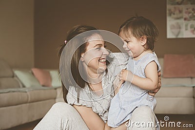 Single mother playing with her little baby at home. Stock Photo