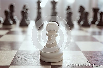 Single pawn against many enemies as a symbol of difficult unequal fight or struggle of minorities. Background in blur. Stock Photo