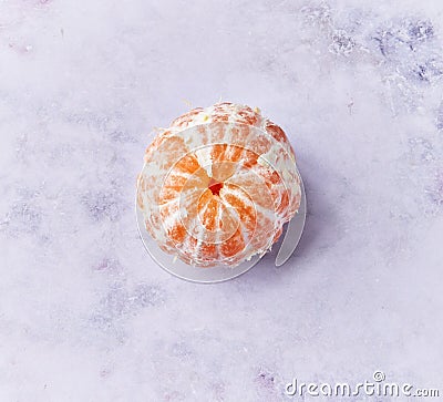 Single peeled tangerine at marble surface Stock Photo