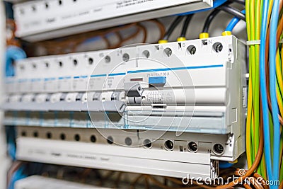 Single phase fuses in OFF position and residual current protection in ON position. Many gray switches in a row, home fuse box. Stock Photo