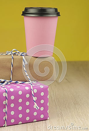 Single pink paper cup of coffee and heap gift boxes Stock Photo