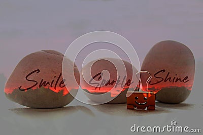 Single positive on three fire red stones - smile sparkle and shine. With smiling paper clip on white table background. Self love. Stock Photo