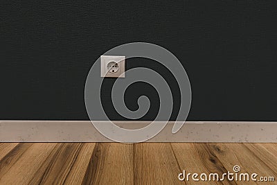 Single power socket in empty wall over wooden floor Stock Photo