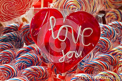 Single red candy lollypop with white text. an i love you lolly with clipping path. Stall with traditional colorful and festive Stock Photo