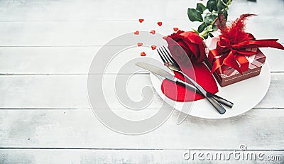 A single red rose with red heart message card on the white dish Stock Photo