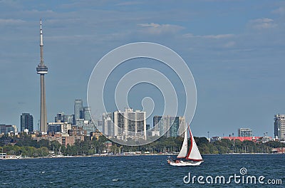 Single sailboat with red rimmed jib sunny Toronto skyline late afternoon Editorial Stock Photo