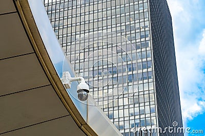 Single Security Camera on facade of contemporary business skyscraper on sunny summer day, security camera on metal beam Stock Photo