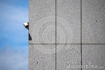 Single security camera mounted on a ventilated marble wall Stock Photo