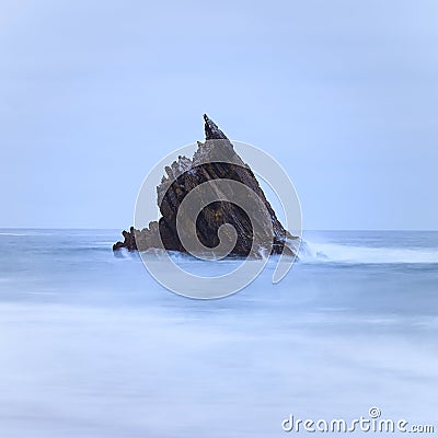 Single sharp rock on the middle of the sea Stock Photo