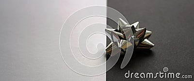 Single shiny silver gift bow on a black background. White backdrop. Festive mock up Stock Photo