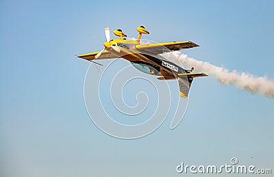 Single small propeller airplane performing aerobatics with smoke trails Editorial Stock Photo