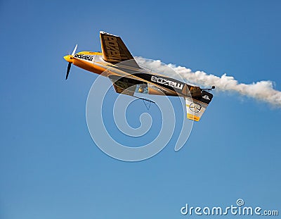 Single small propeller airplane performing aerobatics with smoke trails Editorial Stock Photo