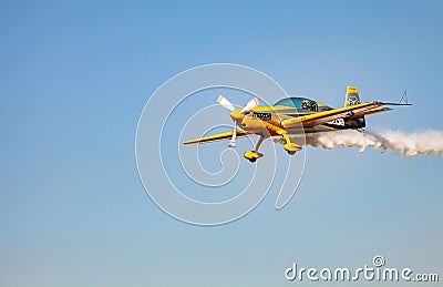 Single small propeller airplane performing aerobatics with smoke trails Editorial Stock Photo