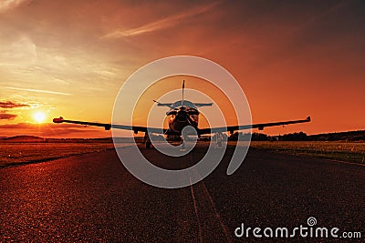 Single turboprop aircraft on evening runway. Stock Photo