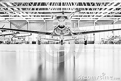 Single turboprop aircraft Pilatus PC-12 in hangar. S Stock Photo