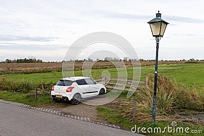 Single White Car Parked along a Rural Green Grass Field in Zaanse Schans Netherlands Editorial Stock Photo