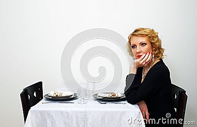 Single woman sits besides served table Stock Photo